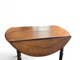 the table is made of wood and has a drop leaf top