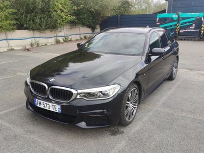 bmw 5 series saloone parked in a parking lot in front of a truck