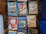 beaucoup de DVD par terre, à côté d'un fauteuil bleu