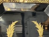 a black and gold tray with two palm trees on it