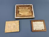 three pieces of old paper and a wooden box on a table