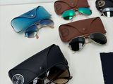 several pairs of sunglasses are laying on a table next to a pair of glasses