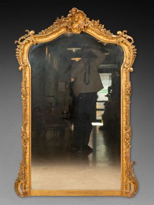 un homme debout devant un miroir dans une pièce