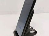 a close up of a cell phone on a stand on a white surface