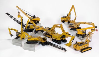 de nombreux engins de chantier miniatures posés sur une surface blanche