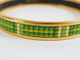 a close up of a green and yellow bracelet on a white surface