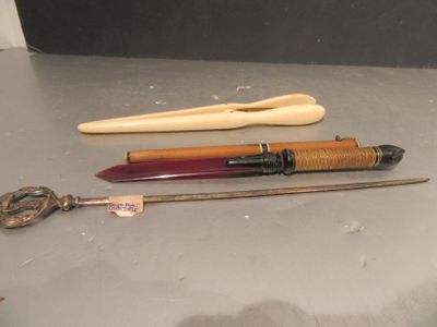 trois stylos différents et une brosse à dents posés sur une table
