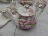a table with a white table cloth and a tea pot and saucer