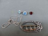 two pairs of earrings and a broochet are sitting on a table