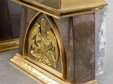 two gold colored boxes with carvings on them in a room