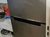 a stainless steel refrigerator in a kitchen with white cabinets