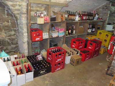 Des bouteilles de soda et d'autres boissons sont empilées sur des étagères dans une pièce