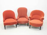 trois chaises orange alignées les unes à côté des autres sur un sol blanc