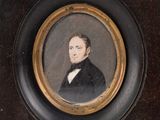 portrait d'un homme en costume noir et nœud papillon, dans un cadre doré
