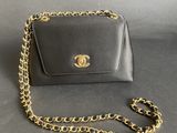 a black purse with a gold chain around it