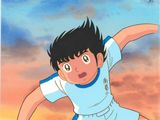 animation représentant un jeune garçon vêtu d'un maillot bleu et blanc en train de lancer un ballon de foot