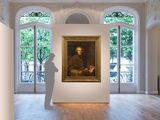 painting of a man standing in front of a painting in a large room