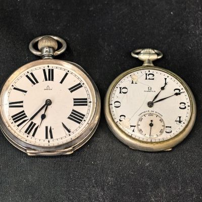deux vieilles montres de poche posées l'une à côté de l'autre sur une table