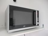 une photo d'un micro-ondes posé sur une étagère dans une cuisine