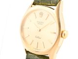 an image of a gold watch with a green strap