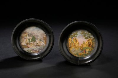 une paire d'assiettes noires et dorées ornées d'une peinture