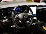 steering wheel and dashboard of a car with a laptop on the dashboard