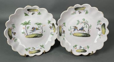 deux assiettes ornées d'oiseaux et de palmiers sur un fond gris
