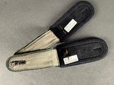 two pairs of black and tan slippers sitting on top of a table