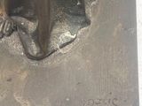 une statue en bronze représentant un chat assis sur une table