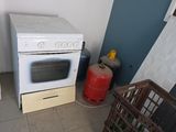 une cuisinière blanche posée dans une cuisine, à côté d'un réfrigérateur
