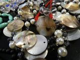 a close up of a necklace with pearls and beads