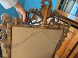 a person standing next to a mirror holding a piece of wood