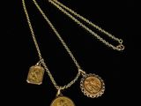 a gold necklace with three charms on it
