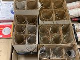 des cartons contenant des verres à vin vides et des bouteilles de vin posés sur une table