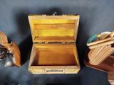 a small wooden box with a spoon and spoon rest on a table