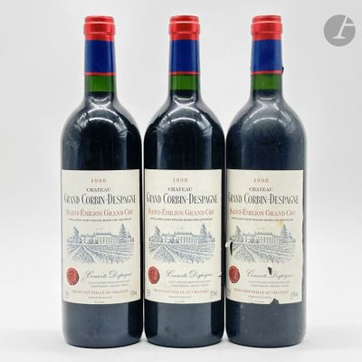 trois bouteilles de vin rouge posées sur une surface blanche