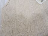 a picture of a white sweater with a tag on it