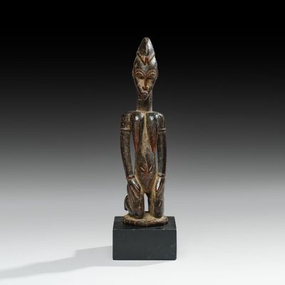 an image of a statue of a person sitting on a black base