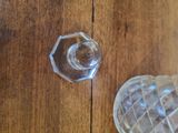a glass candle holder sitting on a table next to a glass candle holder