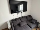 un salon avec un canapé et une télévision à écran plat accrochée au mur