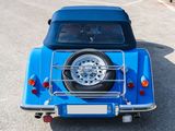 a small blue car parked on the side of the road