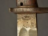 a close up of a knife with a wooden handle on a gray background
