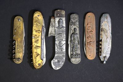 plusieurs types de couteaux sont alignés sur une surface noire