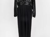 une robe noire et blanche à paillettes posée sur un socle de mannequin