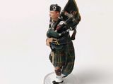 a figurine of a man in a kilt carrying a bagpipe