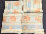 three pillows with floral designs on them sitting on a black surface