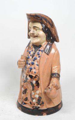 une figurine en céramique représentant un homme coiffé d'un chapeau