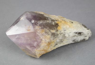 quartz crystal on a rock on a gray surface