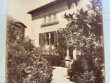 an old photo of a house with a garden in front of it