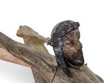 a statue of jesus on a wooden cross with a hat on